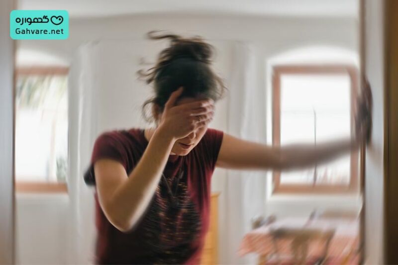 خانمی ایستاده با حالتت سرگیجه