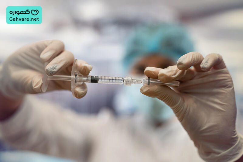 پزشک در حال پر کردن سرنگ آمپول